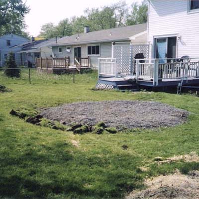 before photo of a back yard in Amherst, NY with large mound of gravel