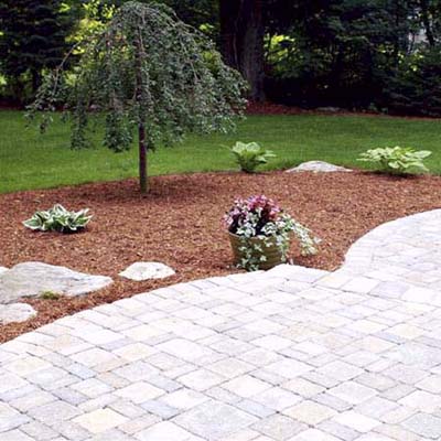 after photo of a back yard in Southborough, MA with stone patio and mulched garden