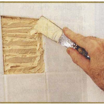 Applying tile adhesive with a putty knife
