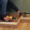 Installing the toekick of a custom entertainment center with drill
