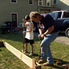 Roger Cook and young boy use edgers to mark out the perimeter of the raised bed