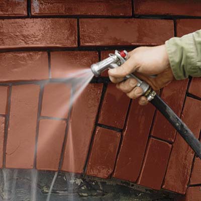 washing away mortar debris from a brick wall
