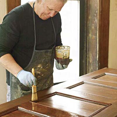 John Thomas brushes on a final coat of satin spar varnish