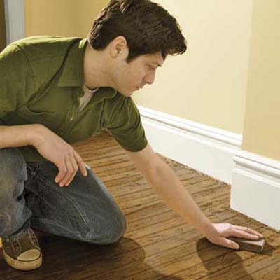 sanding a wood floor with a sanding sponge