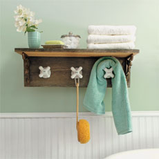 completed towel rack made from vintage taps with shelf installed in a green bathroom