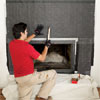 man securing metal lath over the felt of a fireplace to create a stone veneer surround