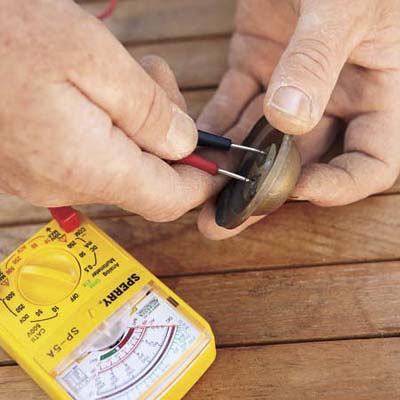 man testing a doorbell with a multimeter