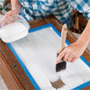 hand brushing latex primer on a cabinet door