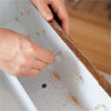 hand screwing cup hooks to inside of cabinet