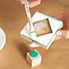applying white paint to one of the stamps