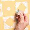 using the circle stamp on a yellow-painted wall