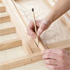 hands marking wood to cut and install the trim for building a dog gate