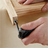 hands using an allen wrench to install the insert nuts into the legs while building a dog gate