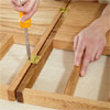 hands attaching hinges to connect the sections of the a dog gate