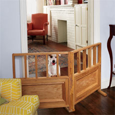 small dog standing up on a dog gate set up between two rooms