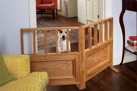 small dog standing up on a dog gate set up between two rooms