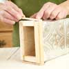 hands working with a wooden and tin box