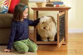 little girl petting a dog in a pet crate that doubles as a side table