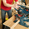 Mark Powers uses a miter saw to cut pieces for a dog crate
