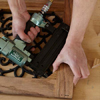 Mark Powers uses a pneumatic brad nailer to attach corner blocks to the door frame of a dog crate