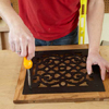 Mark Powers attaches a metal grille from a cabinet to the door frame of a dog crate