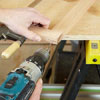 Mark Powers drills pilot holes into the face frame of a dog crate