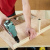 Mark Powers attaches the floor support to a side panel of a dog crate