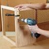 Mark Powers attaches the side panels to the face frame of a dog crate