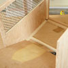 Mark Powers inserts the floorboard into the bottom of a dog crate