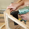 Mark Powers attaches corner blocking to a side panel of a dog crate in order to attach the top piece