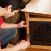 Mark Powers attaches the latch to the face frame of the finished dog crate