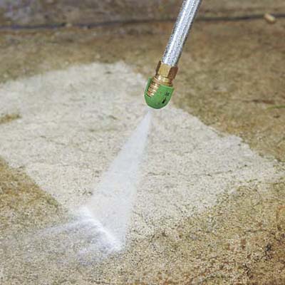 pressure-washing the concrete walkway to prepare for resurfacing
