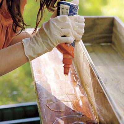 woman gluing trim to flower box