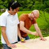 two men tracing circle for cornhole game board