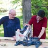 two men sawing a two by four for ladder golf game set