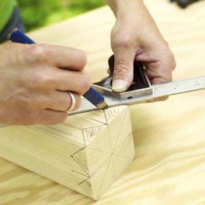 man marking wood to make king crown for yard game of kubb