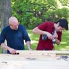 two men drilling holes in rungs for ladder golf game set