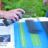 people taping off and painting the lines while building a ricochet game board