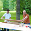 two men positioning frames for cornhole game board