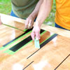 people removing the tape used to mask the lines while building a ricochet game board