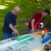 man spray painting wood