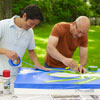 two men taping off design for cornhole game board