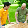 people applying the buff and finish coats while building a ricochet game board