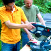 people cutting the sides ends and center rail while building a ricochet game board