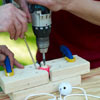 man drilling hole in golf ball for ladder golf game set