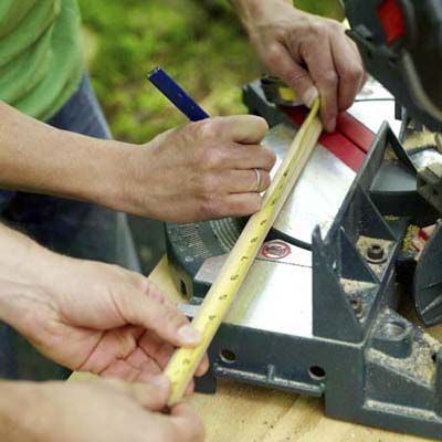 men measuring dowels for kubb game