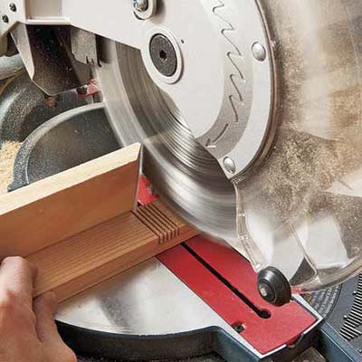 Mark Powers uses a miter saw to make the notch cuts on the leg pieces of a bar cart