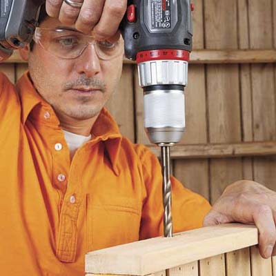 Mark Powers drills a pilot hole for the bottom tray of the bar cart