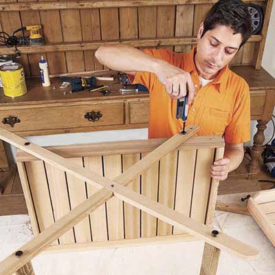 Mark Powers attaches the crosspieces to the bottom tray of the bar cart