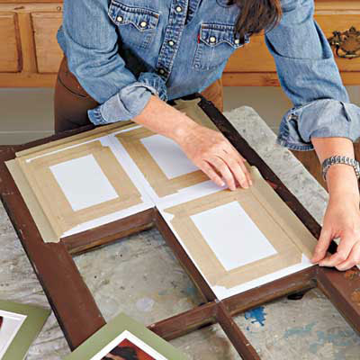 woman arranges the matted photos to the back side of the window